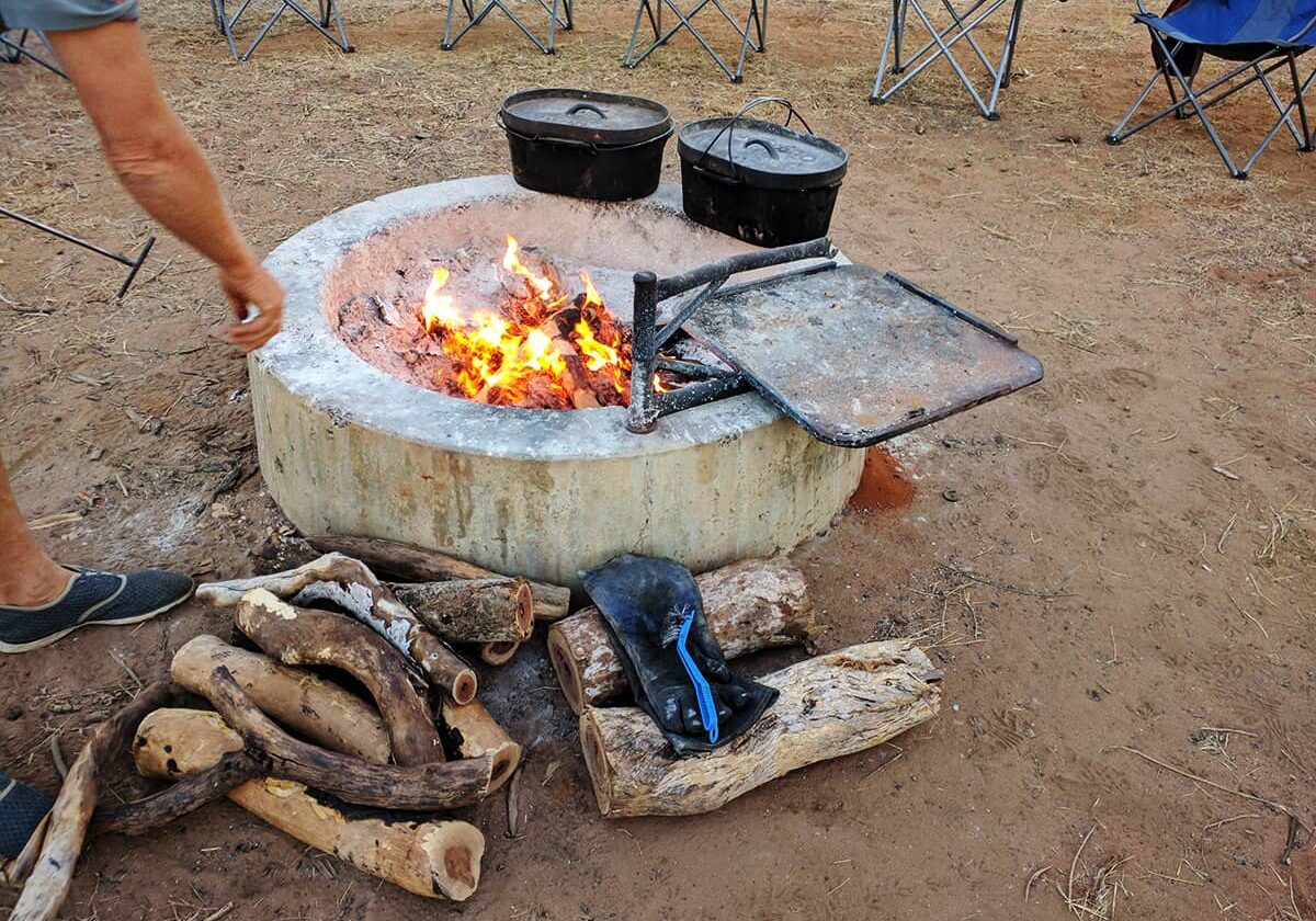 Cast iron camp ovens are used to cook over the coals of a campfire at Windjana Gorge National Park, The Kimberley.