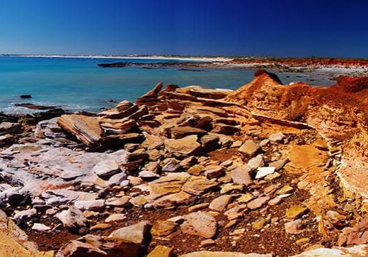 The red rocks of Gantheaume Point, Broome contrast with the turquoise waters of the Indian Ocean & white sand of Cable Beach.